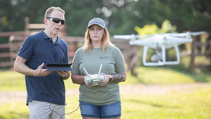 Bailey Wolf flying drone with Dr. Toby Dogwiler at Shealy Farm.